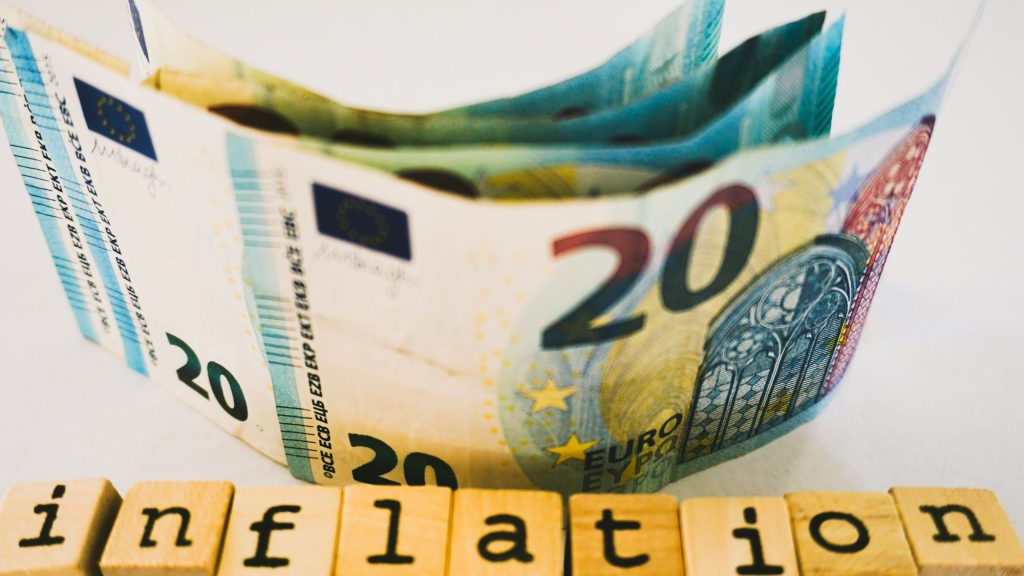 Bancnote de 20 de euro și cuburi de lemn care formează cuvântul „inflation”